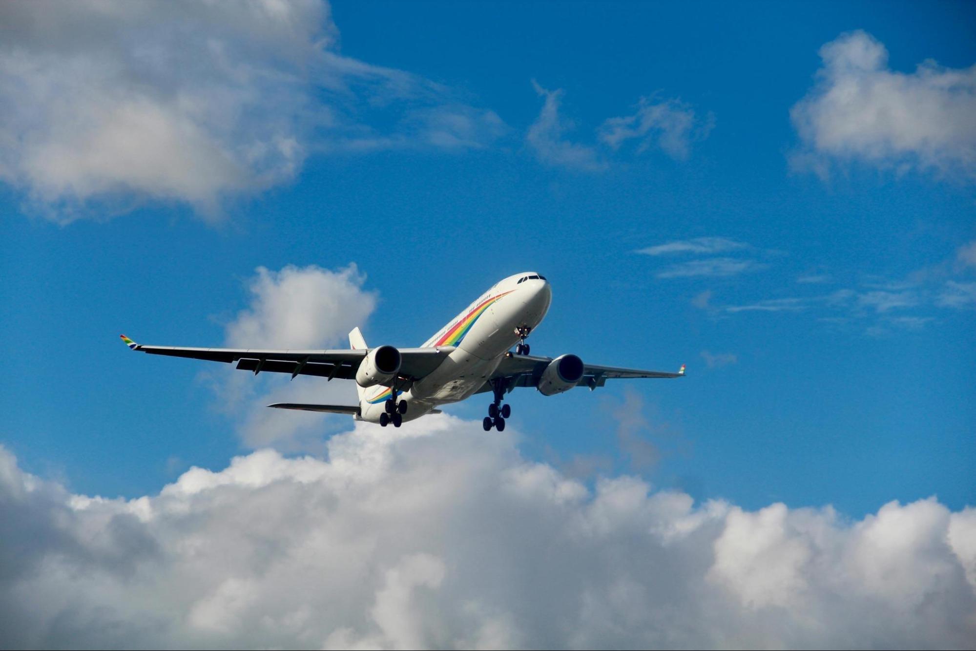 Commercial Airplane Soaring through Blue Sky and Clouds