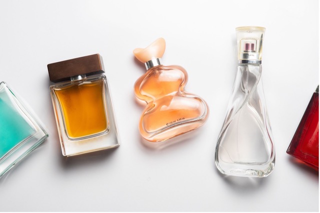 colourful beautiful perfume bottles on a plane white surface