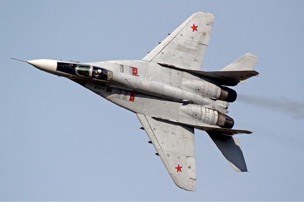 A Russian Air Force Mikoyan-Gurevich MiG-29S fighter jet in a steep climb against a blue sky.